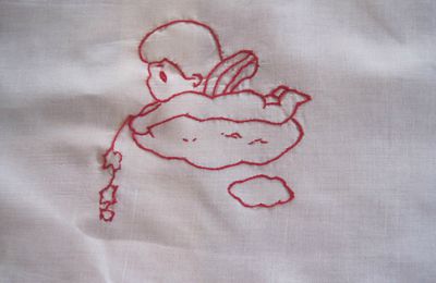 un petit ange en broderie rouge