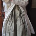 Mlle SOPHIE : Redingote écrue en popeline de coton et robe en voile de coton à superposer sur un jupon écru en organdi...
