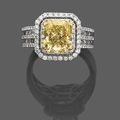 Bague double entourage en or gris, ornée au centre d'un diamant coussin de couleur Fancy Yellow