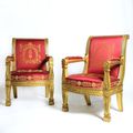 Importante paire de larges fauteuils d'apparat à dossiers légèrement renversés, en hêtre mouluré, sculpté et doré. Epoque Empire