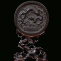 A silver plated bronze mirror with carved wood base, China, Ming Dynasty, 16th century