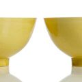 A fine pair of Imperial yellow-glazed porcelain bowls, underglaze blue Kangxi six-character marks and period