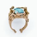 Bague en or jaune sertie d'une topaze bleu ornée d'un couple ciselé sur la monture. Travail italien