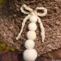 chapeau au crochet en laine filée main de couleur praline moucheté beige clair, garnit de petites boules de laine feutrées