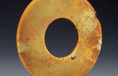 A mottled russet and pale greenish-buff jade huan disc, North-West China, 2nd-1st millenium BC