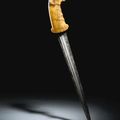 A Mughal carved marine ivory-hilted dagger with ram's head, 17th century