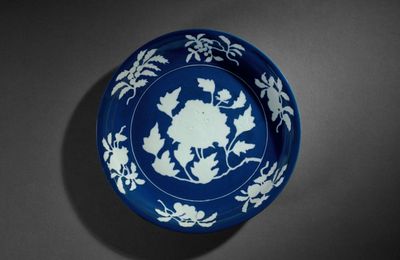 An exceptionally rare and large blue and white reserve-decorated 'peony' dish, Xuande six-character mark in underglaze blue in a line and of the period (1426-1435)