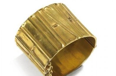 Line Vautrin (1913-1997). Manchette en bronze doré “De la Poudre et des Bals”. 