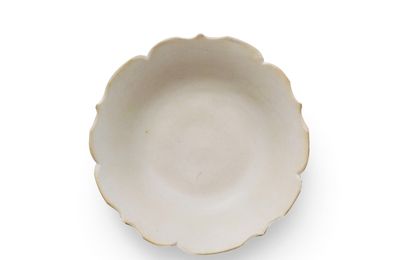 An inscribed Xing white-glazed foliate-rim dish, Tang Dynasty (AD 618-907), Ying mark