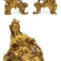 Paire de chenets en bronze ciselé et doré représentant un couple de Chinois tenant un chien et un oiseau. Epoque Louis XV