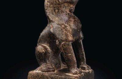 A small blackish stone figure of a seated lion, Tang dynasty (AD 618-907)