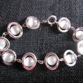 Bracelet perles blanches "oeil de chat" dans ovales argentés