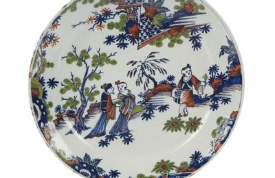 Rouen. Assiette en faïence à décor polychrome deux trois Chinois dans un paysage avec arbustes et rochers, XVIIIème siècle