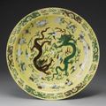 A large green and aubergine yellow-ground biscuit charger. Kangxi mark and period