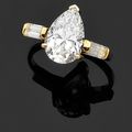 Bague solitaire en or jaune serti d'un diamant de forme poire pesant 4,08 carats, épaulé de diamants baguettes