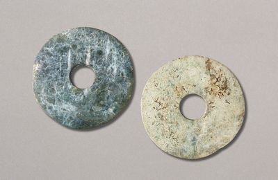 A mottled green jade disc and a greyish-green jade disc, Neolithic period (circa 6500-1700 BC)