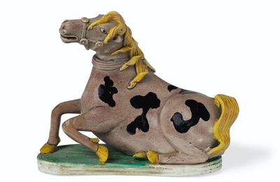 A rare aubergine, yellow, black and green-glazed biscuit figure of a recumbent horse, Qing dynasty, Kangxi period (1662-1722)