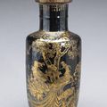 A mirror black glazed porcelain rouleau vase with gilt painted decoration 19th Century