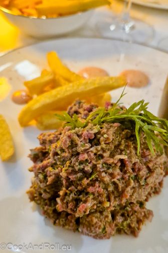 En entrée je me régale de fleurs de courgettes farcies à la volaille, servies dans une sauce onctueuse truffée, simplement parfait! Tandis que ma Végéchérie s’extasie devant une ‘simple’ potage aux poireaux tellement savoureux! Pour suivre, un risotto végétarien et un délicieux Américain pour moi, haché fin et très bien assaisonné, accompagné de frites croustillantes manquant un peu de chaleur, mayo maison et points de sauce relevée, un régal! Un mot sur le délicieux vin rouge (proposé aussi au verre) Kuehn Les Caves de l’Enfer, pinot noir d’Alsace, fruité fruits rouges et cassis, frais, parfait pour accompagner notre repas.