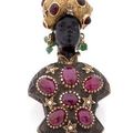 Broche figurant un buste de maure en or jaune et argent sertie de rubis en cabochon.