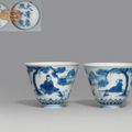 A pair of unusual blue and white 'scholar and pine' wine cups, Kangxi six-character marks in underglaze blue and of the period
