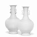 A very rare pair of Imperial white-glazed relief-carved bottle vases, Qianlong seal marks and of the period (1736-1795)