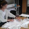 Claire, en train d’effectuer un drapé pour une robe de mariée 