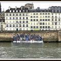 Un artiste accroche la photo géante du naufrage d'une barque de migrants au bord de la Seine à Paris