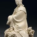 Statuette de Guanyin assis en lalitasana sur un rocher à coté d'un livre en porcelaine émaillée blanc de Chine. Époque Kangxi 