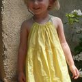 Aliénore porte une robe qui tourne jaune nouée