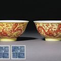 A pair of yellow-ground iron-red 'dragon' bowls. Qianlong underglaze-blue six-character sealmarks and of the period (1736-95)