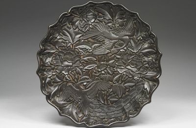 Carved black lacquer plate in the shape of eight-petaled flower with peacock and peony decor, Yuan-Ming dynasty, 14th century