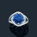 Bague en or gris ornée d'un saphir coussin dans un fin enroulement de diamants de taille brillant