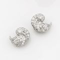 Paire de clips d'oreilles Art Déco en coquillage de platine serti de diamants ronds et baguettes. Vers 1930