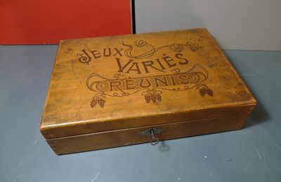 Un coffret en bois " Jeux variés réunis" qui contient des jeux de poche oleins de charme