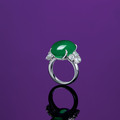 An oval jadeite cabochon and diamond ring