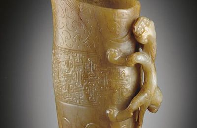 A well-carved greenish-white and pale brown jade rhyton, Song-Ming dynasty, 12th-16th century