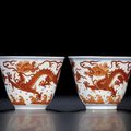 A fine pair of iron-red 'dragon' winecups, seal marks and period of Qianlong (1736-1795)