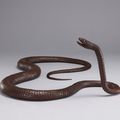 An iron articulated sculpture of a long snake, Early 20th century, signed Muneyoshi (Tanaka Tadayoshi; ?-1958)