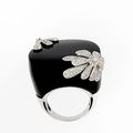Bague en or gris et onyx, ornée de deux fleurs pavées et centrées de diamants. 