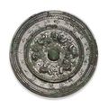 A silvery bronze circular mirror with animals and inscription. Early Tang dynasty, 7th century