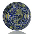 An imperial yellow-glazed blue ground saucer dragon dish. Qianlong seal mark in underglaze blue and of the period