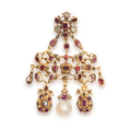 Un pendentif en or jaune, serti de rubis et de diamants, au centre sur une pampille articulée est disposée une perle fine