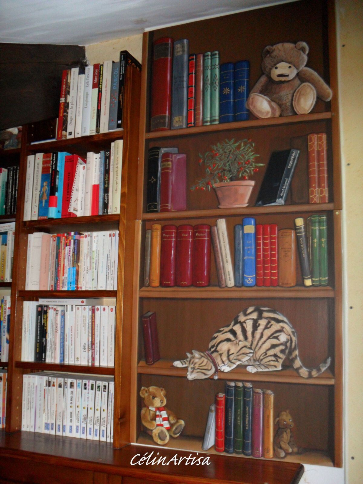 panneau déco bois - bibliothèque en trompe-l'oeil (livres anciens, chat, plante, ours en peluche)