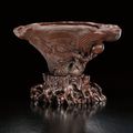 An extremely rare and finely carved rhinoceros horn 'Wood grain and an baxian' libation cup, Ming dynasty, 17th century