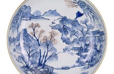 A fine and rare underglaze blue and copper red decorated deep porcelain plate in the style of the 'Master of the Rocks'. 