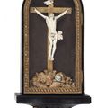 Christ en ivoire sculpté dans son encadrement en bois noirci et doré à motif de pot couvert et guirlande. XVIIIe siècle
