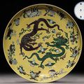 A large and a pair of aubergine and green-enamelled yellow-ground 'dragon' dishes.Kangxi six-character marks