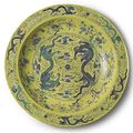 A massive yellow-ground green and aubergine 'dragon' charger. Qing dynasty, Guangxu Period