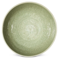 A carved Longquan celadon 'Floral' bowl, Yongle-Xuande period (1403-1435)